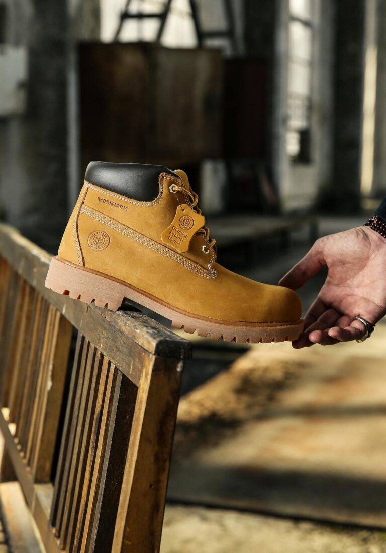 Fashionable leather boot being held in an industrial environment.